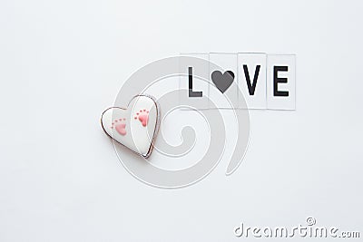 Beautiful children`s footprint in the shape of a heart. In memory of the birth of a child. Love lettering Stock Photo