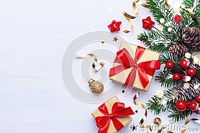 Beautiful Christmas composition on white background with golden Christmas gift boxes, snowy fir branches, conifer cones Stock Photo