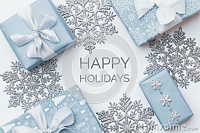 Beautiful christmas gifts and silver snowflakes isolated on white background. Pastel blue colored wrapped xmas boxes. Stock Photo