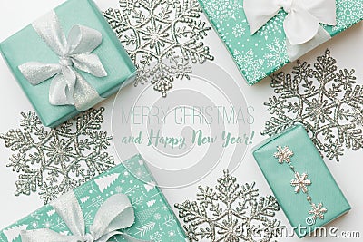 Beautiful christmas gifts and silver snowflakes isolated on white background. Turquoise colored wrapped xmas boxes. Stock Photo