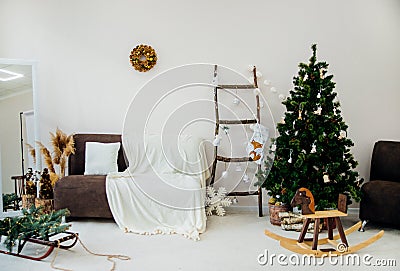 Beautiful Christmas interior. A Christmas tree decorated with toys for the new year. Soft sofa, plaid Stock Photo