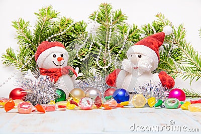 Beautiful Christmas and New Year composition with Santa Claus and snowman in red hats and scarves in front colored toys and in the Stock Photo