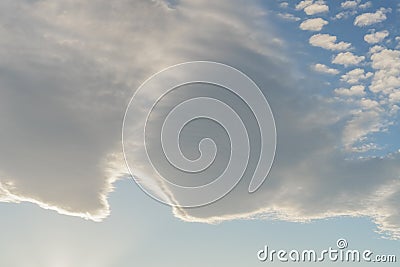 Beautiful cirrus and cumulus clouds on a bright blue sky lit by sunlight Stock Photo