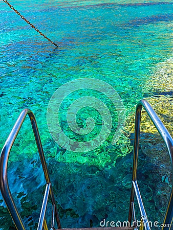 Beautiful clear blue waters of Aegean Sea - edge of the rail steps on the ship Stock Photo