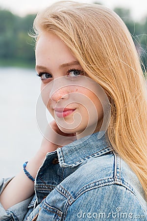 Beautiful close-up portrait of young blonde woman looking with smile at camera Stock Photo