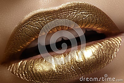 Beautiful closeup with female plump lips with gold color makeup. Fashion celebrate make-up, glitter cosmetic. Christmas style Stock Photo