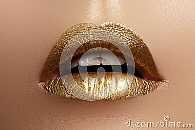 Beautiful closeup with female plump lips with gold color makeup. Fashion celebrate make-up, glitter cosmetic Stock Photo