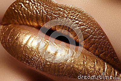 Beautiful closeup with female plump lips with gold color makeup. Fashion celebrate make-up, glitter cosmetic Stock Photo