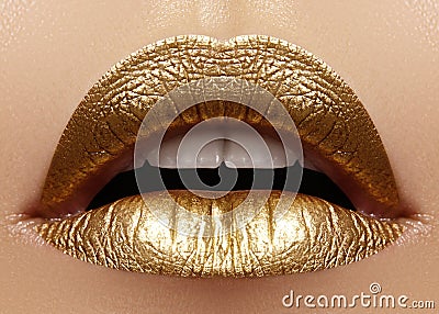 Beautiful closeup with female plump lips with gold color makeup. Fashion celebrate make-up, glitter cosmetic Stock Photo