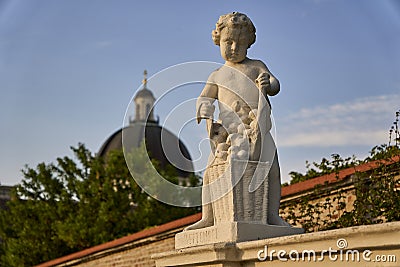 Beautiful closeup of a statue of a little boy filling a basket with apples Stock Photo