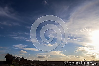 Beautiful clouds in a blue sky over a northern european agricutural field Stock Photo