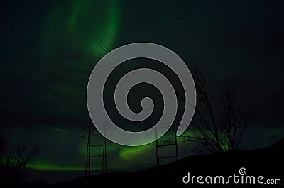 Beautiful colorful aurora borealis dancing on night sky over massive power grid structure Stock Photo