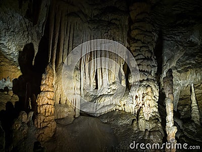 Illuminated dripstones in cave Stock Photo