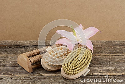 Beautiful composition with pink lily and massage brushes on wooden background Stock Photo