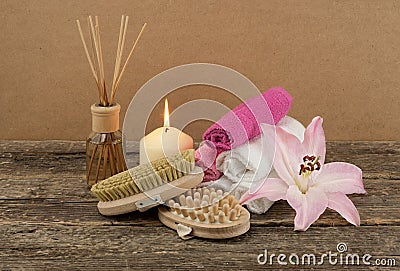 Beautiful composition with white candle, aromatic oil and massage brushes on wooden background Stock Photo