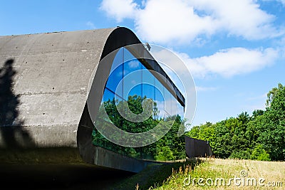 Beautiful concrete building with mirrored windows amidst a beautiful green forest. Modern architecture. Editorial Stock Photo