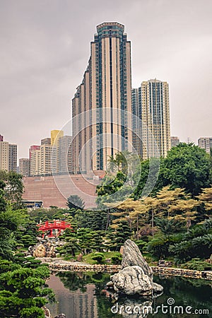 Beautiful contrast between the green trees and blooming flowers and high rise buildings in the Nan Lian Garden in Hong Stock Photo