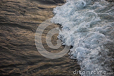 Beautiful contrasting landscape: white foam wave on the dark, smooth surface of the river water Stock Photo