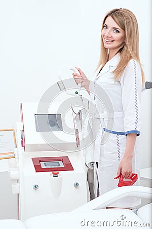 Beautiful cosmetician at her working place is going to apply procedure of laser epilation or rf lifting Stock Photo