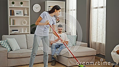 Beautiful couple expressing love, cleaning floor together at home Stock Photo