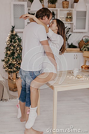 Beautiful couple in love celebreting Christmas. Kitchen breakfast - Image Stock Photo