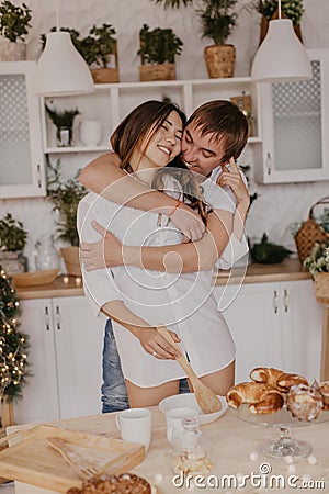 Beautiful couple in love celebreting Christmas. Kitchen breakfast - Image Stock Photo