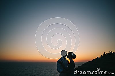 Beautiful couple man and woman on the sunset on the sea Stock Photo