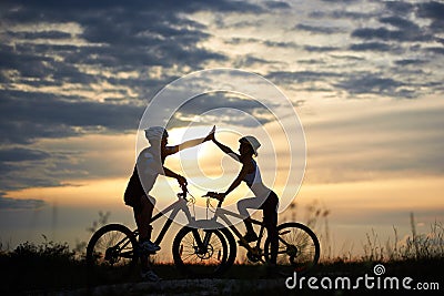 Beautiful couple posing with bicycles in sunset. Stock Photo