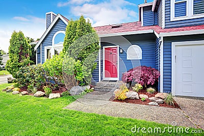 Beautiful curb appeal with blue exterior paint and red roof. Stock Photo