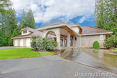 Beautiful curb appeal. Large brick house with three garage spaces and driveway with arch Stock Photo