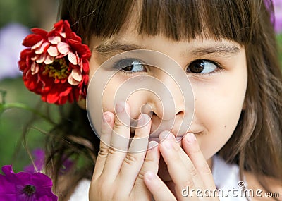 Beautiful curious girl with a flower Stock Photo