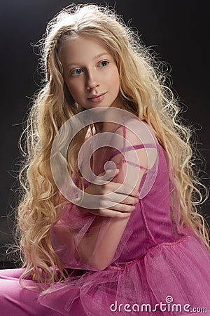 Beautiful curly blonde teenager child girl wearing a pink air dr Stock Photo