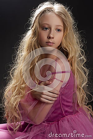 Beautiful curly blonde teenager child girl wearing a pink air dr Stock Photo