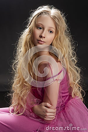 Beautiful curly blonde teenager child girl wearing a pink air dr Stock Photo