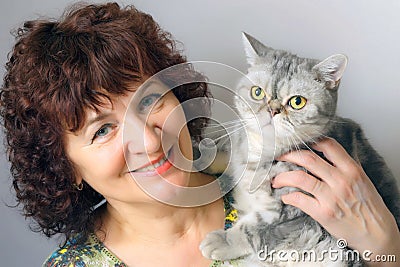 A woman holding a cat of British breed Stock Photo
