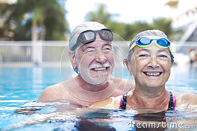 Beautiful and cute close up of two seniors in the pool having fun together - fitness and healthy lifestyle - summertime together Stock Photo