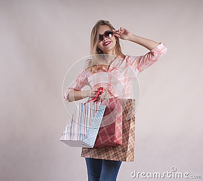 Beautiful cute girl with person shopping bags in jeans sunglasses studio Stock Photo