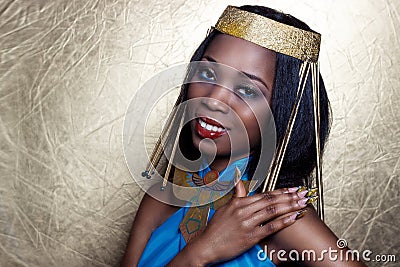 Beautiful dark-skinned girl black woman in the image of the Egyptian queen with red lips bright makeup demonstrates long nails Stock Photo