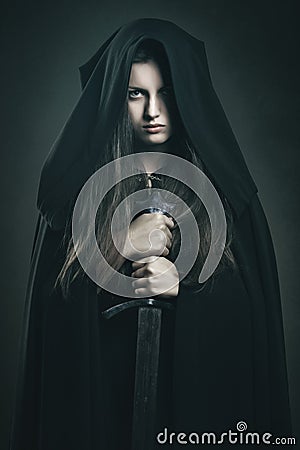 Beautiful dark woman with black robe and sword Stock Photo