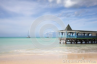 Beautiful day with a view out to sea & the pier of Runaway Beach, Antigua, Caribbean Stock Photo