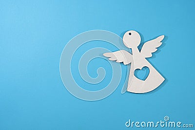 Beautiful decorative angel carved in wood against a blue background. Photo for Christmas and New Year Stock Photo