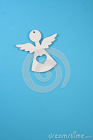 Beautiful decorative angel carved in wood against a blue background. Photo for Christmas and New Year Stock Photo