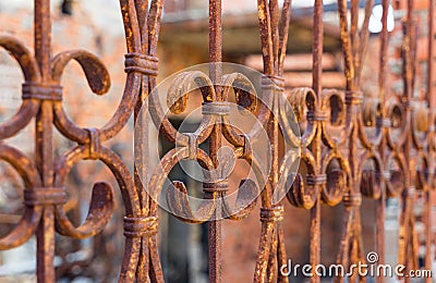 Beautiful decorative metal fence with artistic forging after a fire. Rusty iron guardrail close up. Stock Photo