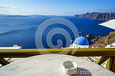 Beautiful deep blue Aegean ocean panoramic sea view and blue church roof from breakfast coffee shop with white marble table Stock Photo