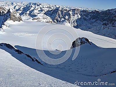 beautiful deep snow tracks from the clariden mountain down towards the glacier firn. Uri Glarus Switzerland Stock Photo