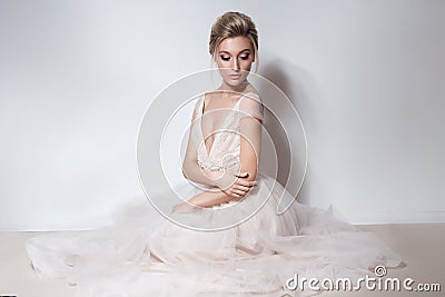 Beautiful delicate bride girl in soft pink skazachno wedding dress with a cut on the chest and back with makeup and evening h Stock Photo