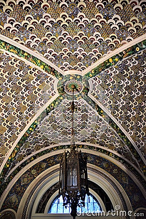 Beautiful detail of a room`s polychromatic ceiling, from which an ancient metal and glass chandelier descends, of the Stibbert mus Editorial Stock Photo