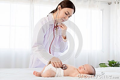 Beautiful doctor hand using stethoscope examining adorable infant heart, asian newborn baby get sick sleep during examine by Stock Photo