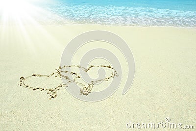 Beautiful drawing on the sand near the sea shore background Stock Photo