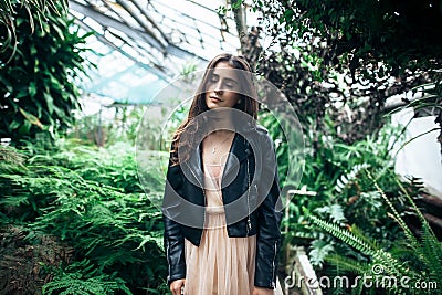 Beautiful dreaming woman with closed eyes posing in garden green Stock Photo